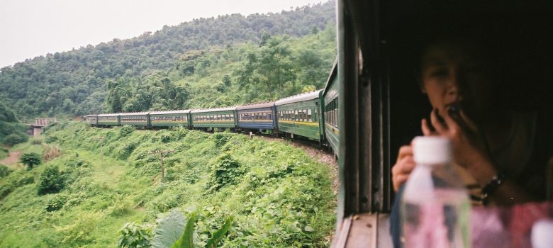 Vietnamese train traveling through lush hills